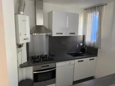 a kitchen with white cabinets and a stove top oven at Appartement proche centre ville in Aix-en-Provence
