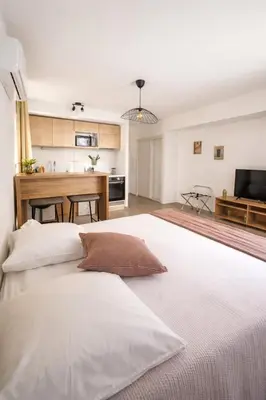 a large white bed in a room with a kitchen at SOUS LES PLATANES in Velaux