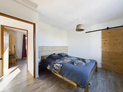 a bedroom with a bed with a wooden headboard at Mas des Oliviers in Eyragues