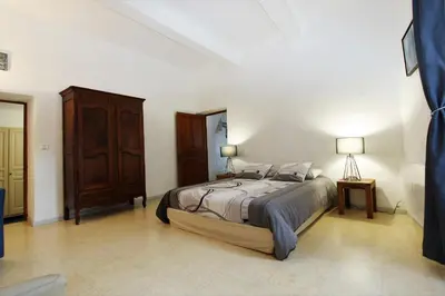a bedroom with a large bed and a wooden cabinet at Gites Provence et Nature - Ambiance familiale et conviviale en Luberon in Cabrières-dʼAvignon