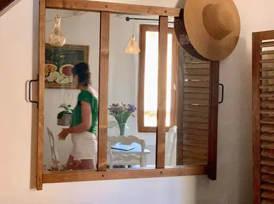 a woman is standing in front of a mirror at Duplex Atelier / coeur de Lourmarin in Lourmarin