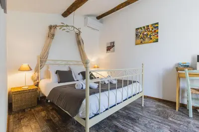 a bedroom with a canopy bed in a room at Chambre d'hôtes - B&B - Fleur de coton chez Manon en Luberon in Lagnes