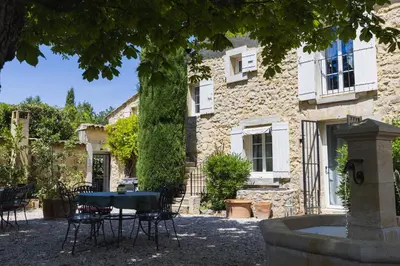 a table and chairs in front of a building at Chambre d'hôtes - B&B - Fleur de coton chez Manon en Luberon in Lagnes