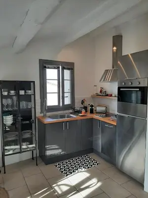 a kitchen with a sink and a stove top oven at Vue imprenable sur la Sorgue in LʼIsle-sur-la-Sorgue