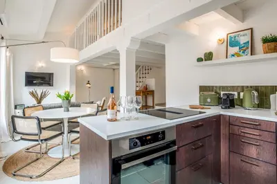 a kitchen with a table and a dining room at Appartement Cezanne - Welkeys in Aix-en-Provence