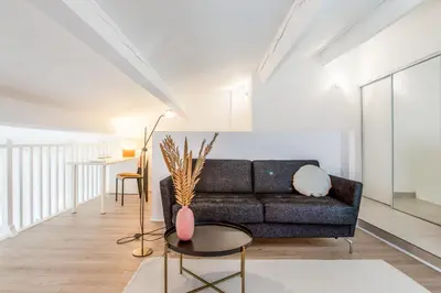 a living room with a couch and a table at Appartement Cezanne - Welkeys in Aix-en-Provence