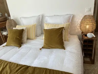 a large white bed with four pillows on it at Chambre d'hôtes de la cime in Cabrières-dʼAigues