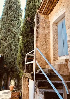a staircase leading up to a building with a blue door at Maison de caractère au coeur de la Provence in Robion en Luberon