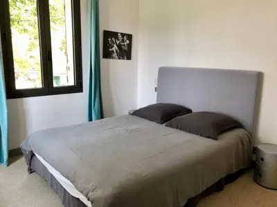 a bedroom with a large bed with two pillows at Maison contemporaine dans le village d'Eygalières in Eygalières