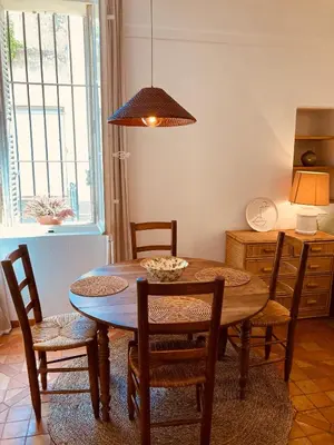 a dining room with a wooden table and chairs at Appartement de charme au coeur du vieux Aix. in Aix-en-Provence