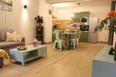 a living room with a table and a kitchen at Chez Franck et Gisele in LʼIsle-sur-la-Sorgue