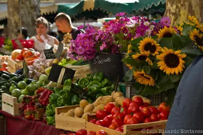 a farmers market with fruits and vegetables and flowers at Aix Homes 