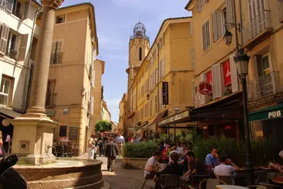 a group of people sitting at tables in a street at Aix Homes 