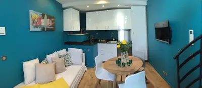 a living room with a white couch and a table at AJOUCADOU le nid in Lourmarin