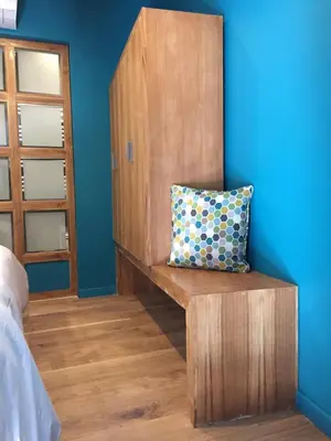 a pillow sitting on a wooden bench in a bedroom at AJOUCADOU le nid in Lourmarin