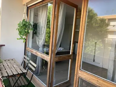 a wooden door with a window on a balcony at Cozy Studio with balcony and free parking in Aix-en-Provence