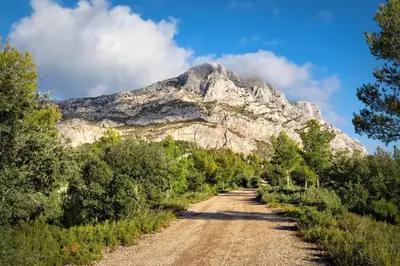 a dirt road with a mountain in the background at Cozy Studio with balcony and free parking in Aix-en-Provence