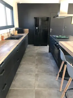 a kitchen with a black refrigerator and a counter at La Petite Reine in Villes-sur-Auzon