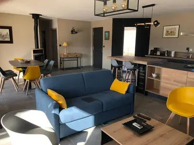 a living room with a blue couch and a kitchen at La Petite Reine in Villes-sur-Auzon