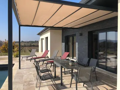 a patio with tables and chairs and a pool at La Petite Reine in Villes-sur-Auzon