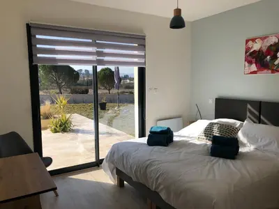 a bedroom with a bed and a sliding glass door at La Petite Reine in Villes-sur-Auzon