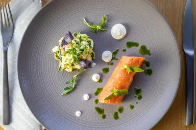 a plate of food with a piece of fish and salad at Le Château Olive et Raisin in Fontaine-de-Vaucluse