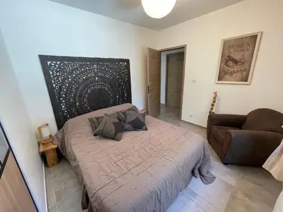 a bedroom with a bed and a chair in it at Villa en Provence in Saint-Saturnin-les-Apt