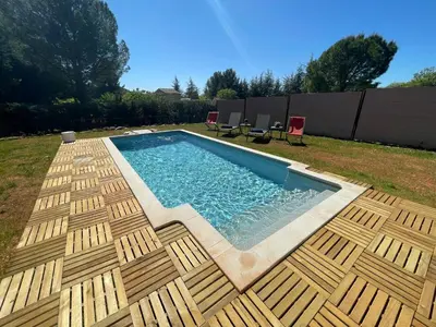 a swimming pool with a wooden deck and chairs at Villa en Provence in Saint-Saturnin-les-Apt
