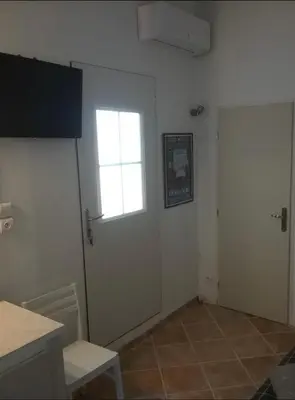a white room with a door and a window at UNE CHAMBRE EN VILLE in LʼIsle-sur-la-Sorgue