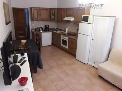 a kitchen with a white refrigerator and a table at Apt en Luberon appartement 3 chambres et garage privée in Apt