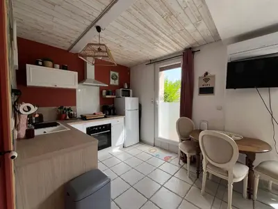 a kitchen with a table and a dining room at Terrama de l'isle in LʼIsle-sur-la-Sorgue