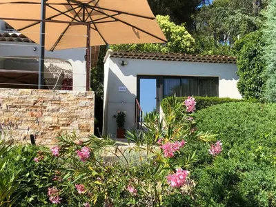 a house with an umbrella and some pink flowers at The View Aix-en-Provence in Aix-en-Provence