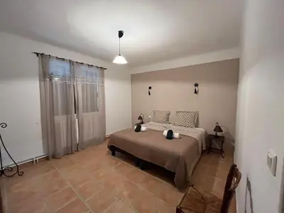 a bedroom with a bed and a large window at Mas dans les lavandes in Ménerbes