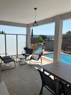 a patio with chairs and a table and a pool at Les jardins de la Gravière à 5 mn de Lourmarin avec piscine privée in Puyvert