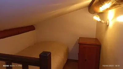 a small bedroom with a bed and a night stand at L' ecurie de Florent et Spa in Cheval-Blanc