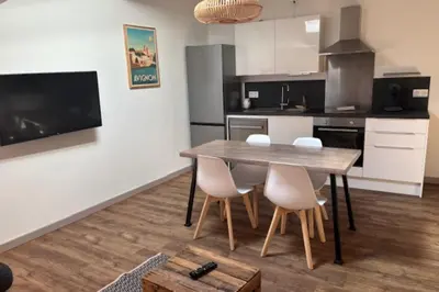 a kitchen with a wooden table and white chairs at 