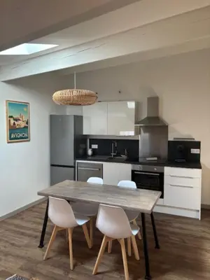 a kitchen with a wooden table and white chairs at 