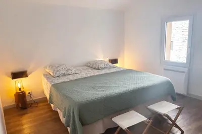 a bedroom with a bed with two chairs and a window at 
