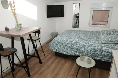 a hotel room with a bed and a table and a desk at Under the Provençal Sun in LʼIsle-sur-la-Sorgue