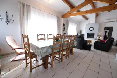 a dining room table and chairs in a living room at pretty holiday rental with swimming pool in isle-sur-la-sorgue, in the département of vaucluse, in provence 4 people in LʼIsle-sur-la-Sorgue
