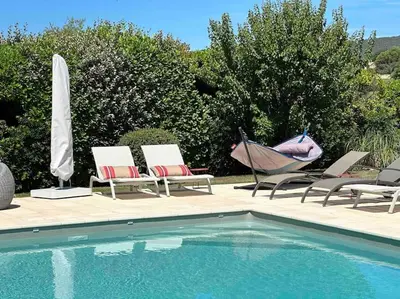 a group of chairs and a swimming pool with a umbrella at La Cath - Villa avec piscine - Gordes in Gordes