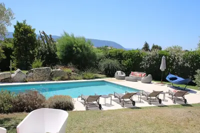 a swimming pool with chairs and a couch and a table at La Cath - Villa avec piscine - Gordes in Gordes