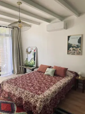 a bedroom with a large bed with a red blanket at Gîte Mas La Bohème Piscine Parking Privé L'Isle-Sur-La-Sorgue in LʼIsle-sur-la-Sorgue