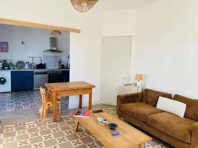 a living room with a couch and a table at Gîte Mas La Bohème Piscine Parking Privé L'Isle-Sur-La-Sorgue in LʼIsle-sur-la-Sorgue