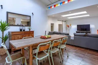 a dining room with a table and chairs and a couch at Lou Roucas : Agréable maison de village avec vue in Fontaine-de-Vaucluse