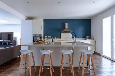 a kitchen with a large island with bar stools at Lou Roucas : Agréable maison de village avec vue in Fontaine-de-Vaucluse