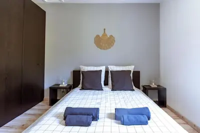 a bedroom with a bed with two blue pillows at Lou Roucas : Agréable maison de village avec vue in Fontaine-de-Vaucluse