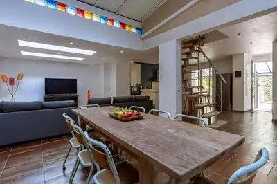 a living room with a wooden table and chairs at Lou Roucas : Agréable maison de village avec vue in Fontaine-de-Vaucluse