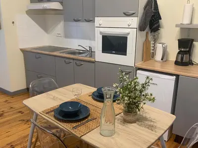 a kitchen with a table with plates and a vase at Lou Magnan in LʼIsle-sur-la-Sorgue
