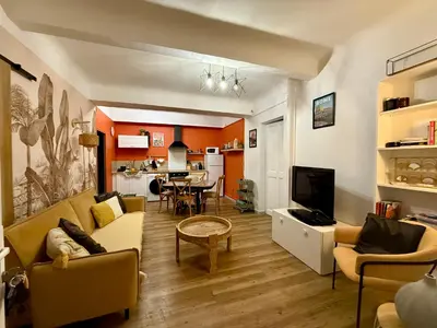 a living room with a couch and a dining room at Sasha'blue-terrasse jardin-park-clim-piscine in LʼIsle-sur-la-Sorgue